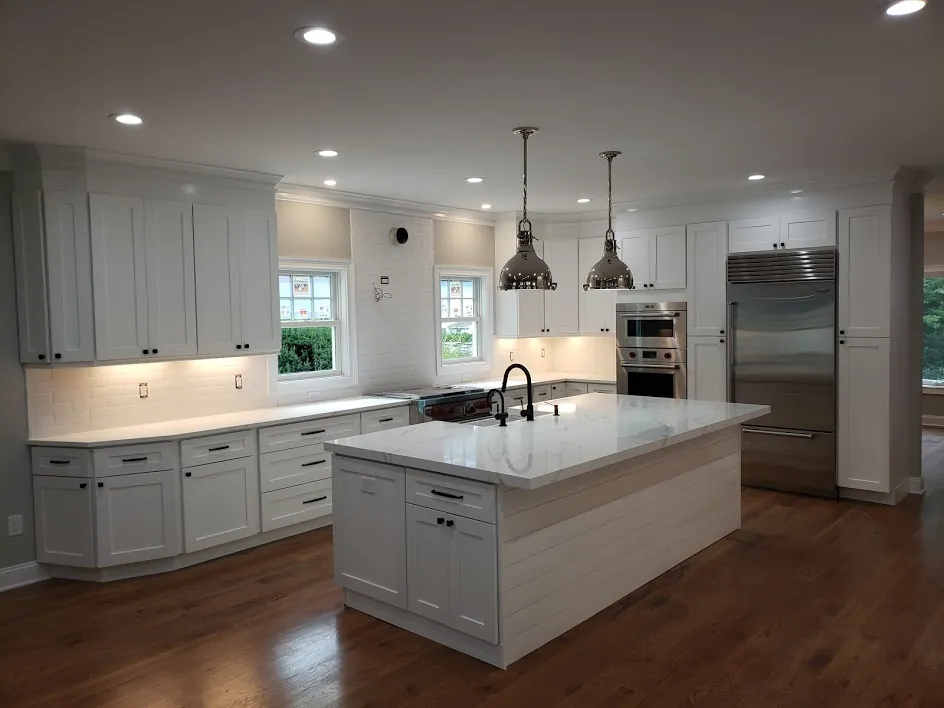 White shaker kitchen with quartz island and pendant lights